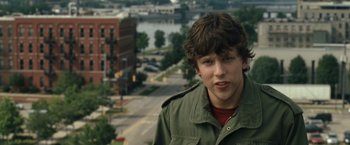 Movie still from “30 Minutes or Less” (2011), directed by Ruben Fleischer – A young man standing on top of a building near a river; Close Up shot, Over the shoulder angle