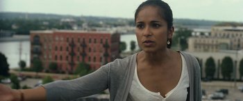 Movie still from “30 Minutes or Less” (2011), directed by Ruben Fleischer – A woman standing on top of a building near a river; Close Up shot, Over the shoulder angle