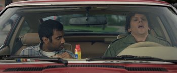 Movie still from “30 Minutes or Less” (2011), directed by Ruben Fleischer – Two men sitting in the back seat of a red car; Medium shot, Over the shoulder angle
