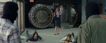 Movie still from “30 Minutes or Less” (2011), directed by Ruben Fleischer – A woman standing in front of two men in front of a bank vault; Wide shot, High angle