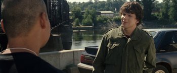 Movie still from “30 Minutes or Less” (2011), directed by Ruben Fleischer – A man standing next to a body of water; Medium shot, Over the shoulder angle