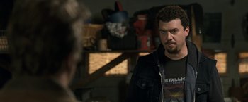 Movie still from “30 Minutes or Less” (2011), directed by Ruben Fleischer – A man standing in front of a mirror in a room; Close Up shot, Over the shoulder angle