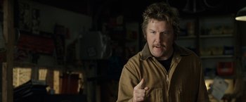 Movie still from “30 Minutes or Less” (2011), directed by Ruben Fleischer – A man in a brown jacket is talking to the camera; Close Up shot, Over the shoulder angle