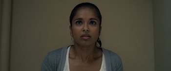 Movie still from “30 Minutes or Less” (2011), directed by Ruben Fleischer – A young woman with brown eyes wearing a white shirt and a gray jacket; Close Up shot, Low angle