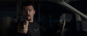 Movie still from “30 Minutes or Less” (2011), directed by Ruben Fleischer – A man in a black shirt is driving a car; Close Up shot, Over the shoulder angle