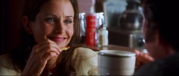 Movie still from “3000 Miles to Graceland” (2001), directed by Demian Lichtenstein – A person sitting at a table with food; Close Up shot, Over the shoulder angle