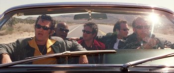 Movie still from “3000 Miles to Graceland” (2001), directed by Demian Lichtenstein – A group of men riding in the back of a car; Medium shot, Low angle
