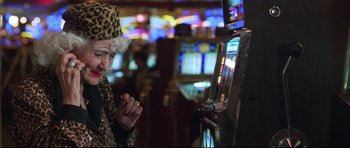 Movie still from “3000 Miles to Graceland” (2001), directed by Demian Lichtenstein – An older woman playing a slot machine in a casino; Close Up shot, Over the shoulder angle