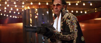 Movie still from “3000 Miles to Graceland” (2001), directed by Demian Lichtenstein – A man dressed as a man with a gun in his hand; Medium shot, Low angle