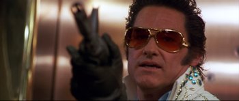 Movie still from “3000 Miles to Graceland” (2001), directed by Demian Lichtenstein – A person wearing sunglasses and holding a gun; Close Up shot, Low angle
