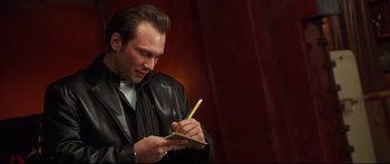 Movie still from “3000 Miles to Graceland” (2001), directed by Demian Lichtenstein – A man writing on a piece of paper with a pencil; Close Up shot, Low angle