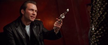 Movie still from “3000 Miles to Graceland” (2001), directed by Demian Lichtenstein – A man in a leather jacket holding a gun; Close Up shot, Low angle
