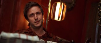 Movie still from “3000 Miles to Graceland” (2001), directed by Demian Lichtenstein – A person sitting in front of a lamp; Close Up shot, Low angle