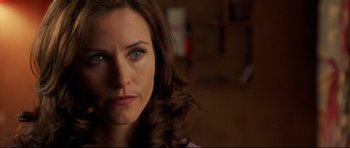 Movie still from “3000 Miles to Graceland” (2001), directed by Demian Lichtenstein – A woman's face in a dark room; Close Up shot, Over the shoulder angle