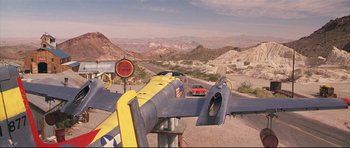 Movie still from “3000 Miles to Graceland” (2001), directed by Demian Lichtenstein – An airplane is parked on the side of the road; Extreme Wide shot, High angle