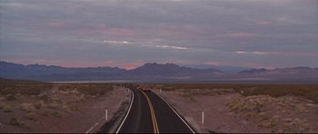 Movie still from “3000 Miles to Graceland” (2001), directed by Demian Lichtenstein – A car driving down a road in the middle of the desert; Extreme Wide shot, High angle