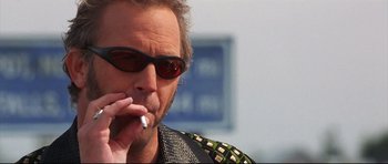 Movie still from “3000 Miles to Graceland” (2001), directed by Demian Lichtenstein – A person smoking a cigarette; Close Up shot, Low angle