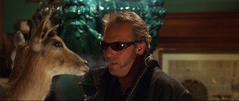 Movie still from “3000 Miles to Graceland” (2001), directed by Demian Lichtenstein – A person wearing sunglasses smoking a cigarette; Close Up shot, Over the shoulder angle