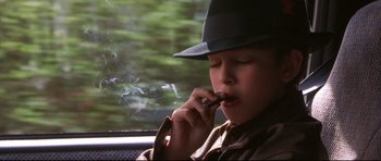 Movie still from “3000 Miles to Graceland” (2001), directed by Demian Lichtenstein – A young man smoking a cigarette while sitting in a car; Close Up shot, High angle