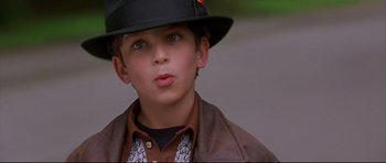 Movie still from “3000 Miles to Graceland” (2001), directed by Demian Lichtenstein – A young boy wearing a black hat and a brown jacket; Close Up shot, High angle