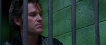 Movie still from “3000 Miles to Graceland” (2001), directed by Demian Lichtenstein – A person behind a metal fence; Close Up shot, Low angle