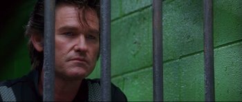 Movie still from “3000 Miles to Graceland” (2001), directed by Demian Lichtenstein – A person behind a metal fence; Close Up shot, Low angle
