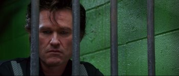 Movie still from “3000 Miles to Graceland” (2001), directed by Demian Lichtenstein – A person behind a metal fence; Close Up shot, Low angle