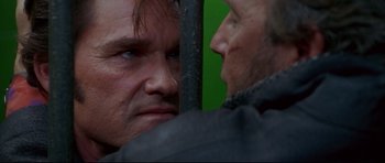 Movie still from “3000 Miles to Graceland” (2001), directed by Demian Lichtenstein – Two men face each other in front of a green background; Close Up shot, Over the shoulder angle