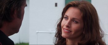 Movie still from “3000 Miles to Graceland” (2001), directed by Demian Lichtenstein – A woman smiling for the camera; Close Up shot, Over the shoulder angle