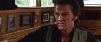 Movie still from “3000 Miles to Graceland” (2001), directed by Demian Lichtenstein – A person sitting in front of a window; Close Up shot, Over the shoulder angle