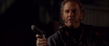 Movie still from “3000 Miles to Graceland” (2001), directed by Demian Lichtenstein – A person holding a gun; Close Up shot, Low angle