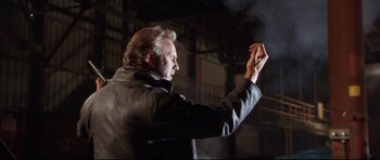 Movie still from “3000 Miles to Graceland” (2001), directed by Demian Lichtenstein – A man in a leather jacket holding something in his hand; Medium shot, Low angle