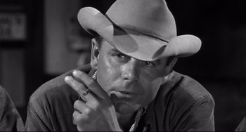 Movie still from “3:10 to Yuma” (1957), directed by Delmer Daves – A black and white photo of a man wearing a cowboy hat; Close Up shot, Low angle