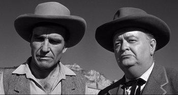 Movie still from “3:10 to Yuma” (1957), directed by Delmer Daves – A black and white photo of two men wearing hats; Close Up shot, Low angle