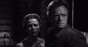 Movie still from “3:10 to Yuma” (1957), directed by Delmer Daves – A man and a woman standing next to each other; Close Up shot, Low angle