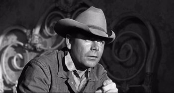 Movie still from “3:10 to Yuma” (1957), directed by Delmer Daves – A black and white photo of a man wearing a cowboy hat; Close Up shot, Low angle