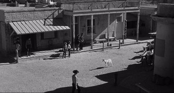 Movie still from “3:10 to Yuma” (1957), directed by Delmer Daves – An old photo of a man and a dog in a town; Extreme Wide shot, High angle