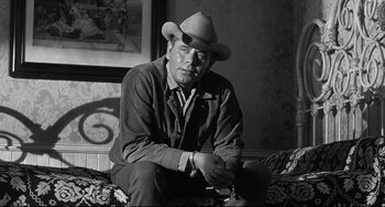 Movie still from “3:10 to Yuma” (1957), directed by Delmer Daves – A black and white photo of a man wearing a cowboy hat; Medium shot, Low angle