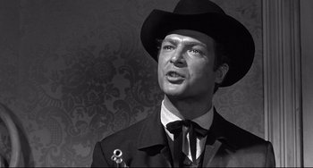 Movie still from “3:10 to Yuma” (1957), directed by Delmer Daves – A black and white photo of a man wearing a suit and a hat; Close Up shot, Low angle