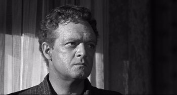 Movie still from “3:10 to Yuma” (1957), directed by Delmer Daves – Black and white photograph of a man looking at the camera; Close Up shot, Low angle