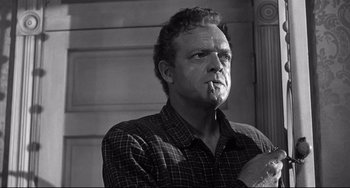 Movie still from “3:10 to Yuma” (1957), directed by Delmer Daves – Black and white photograph of a man smoking a cigarette; Close Up shot, Low angle