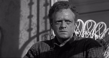 Movie still from “3:10 to Yuma” (1957), directed by Delmer Daves – A black and white photo of a man in a plaid shirt; Close Up shot, Low angle