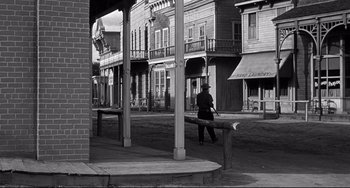 Movie still from “3:10 to Yuma” (1957), directed by Delmer Daves – A man walking down a street near a row of buildings; Extreme Wide shot, Low angle