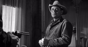 Movie still from “3:10 to Yuma” (1957), directed by Delmer Daves – A black and white photo of a man in a cowboy hat; Medium shot, Low angle