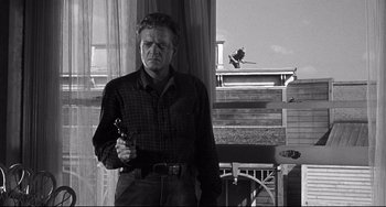 Movie still from “3:10 to Yuma” (1957), directed by Delmer Daves – A black and white photo of a man holding a gun; Medium shot, Low angle