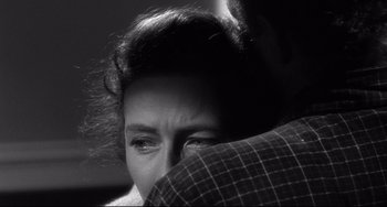 Movie still from “3:10 to Yuma” (1957), directed by Delmer Daves – A black - and - white photo of a woman holding a man's arm; Close Up shot, Over the shoulder angle