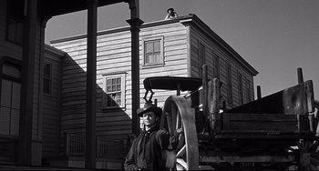 Movie still from “3:10 to Yuma” (1957), directed by Delmer Daves – A man standing in front of an old house; Wide shot, Low angle