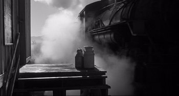 Movie still from “3:10 to Yuma” (1957), directed by Delmer Daves – An image of a steam train going down the tracks in black and white; Wide shot, High angle