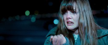 Movie still from “4.3.2.1.” (2010), directed by Mark Davis – A young woman is crying in the dark; Close Up shot, High angle