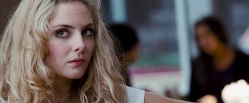 Movie still from “4.3.2.1.” (2010), directed by Mark Davis – A person with long blonde hair; Close Up shot, Over the shoulder angle